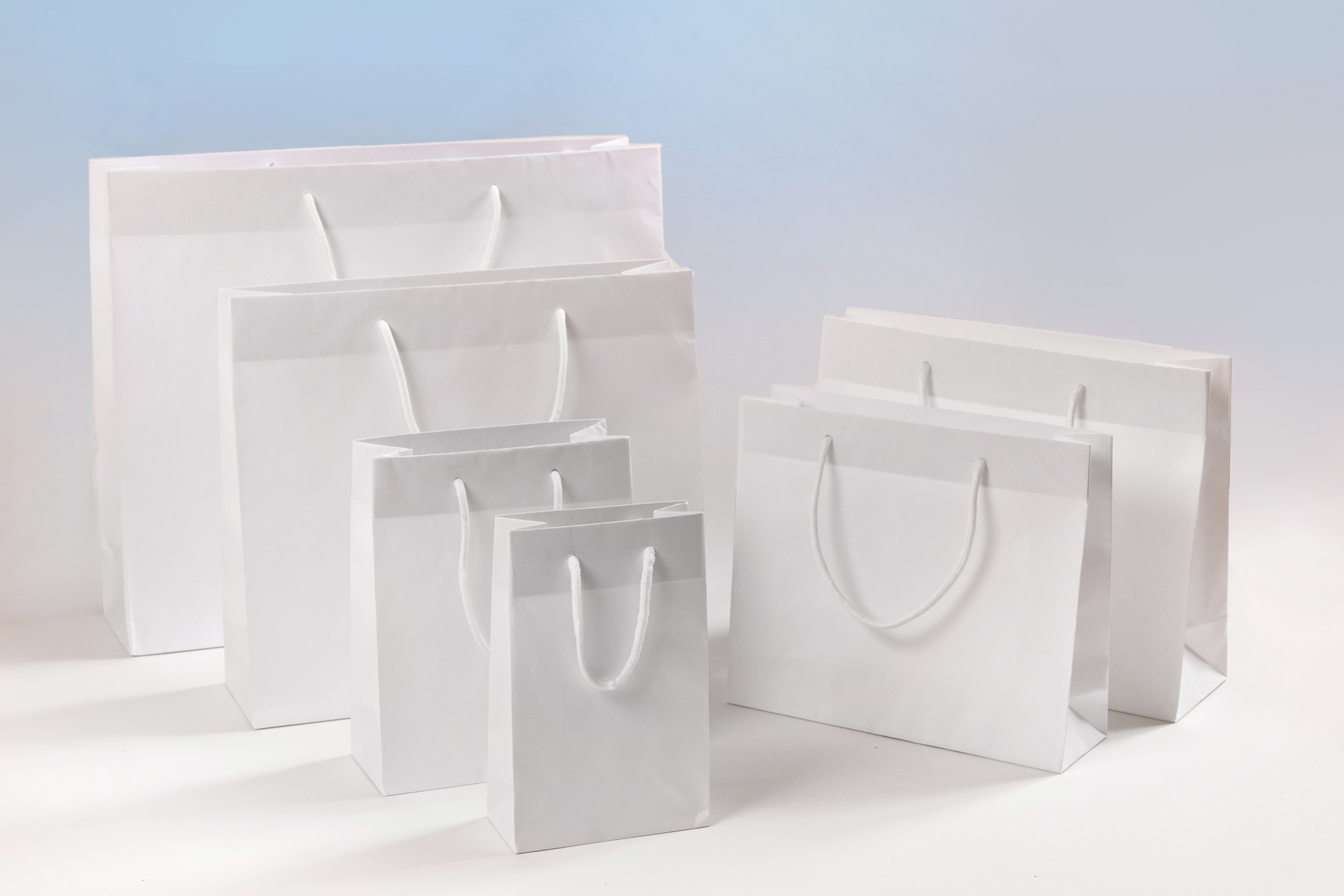 Gruppenbild SALE Papiertragetaschen aus Sealingpapier (gerippt) mit Stoffkordeln weiß