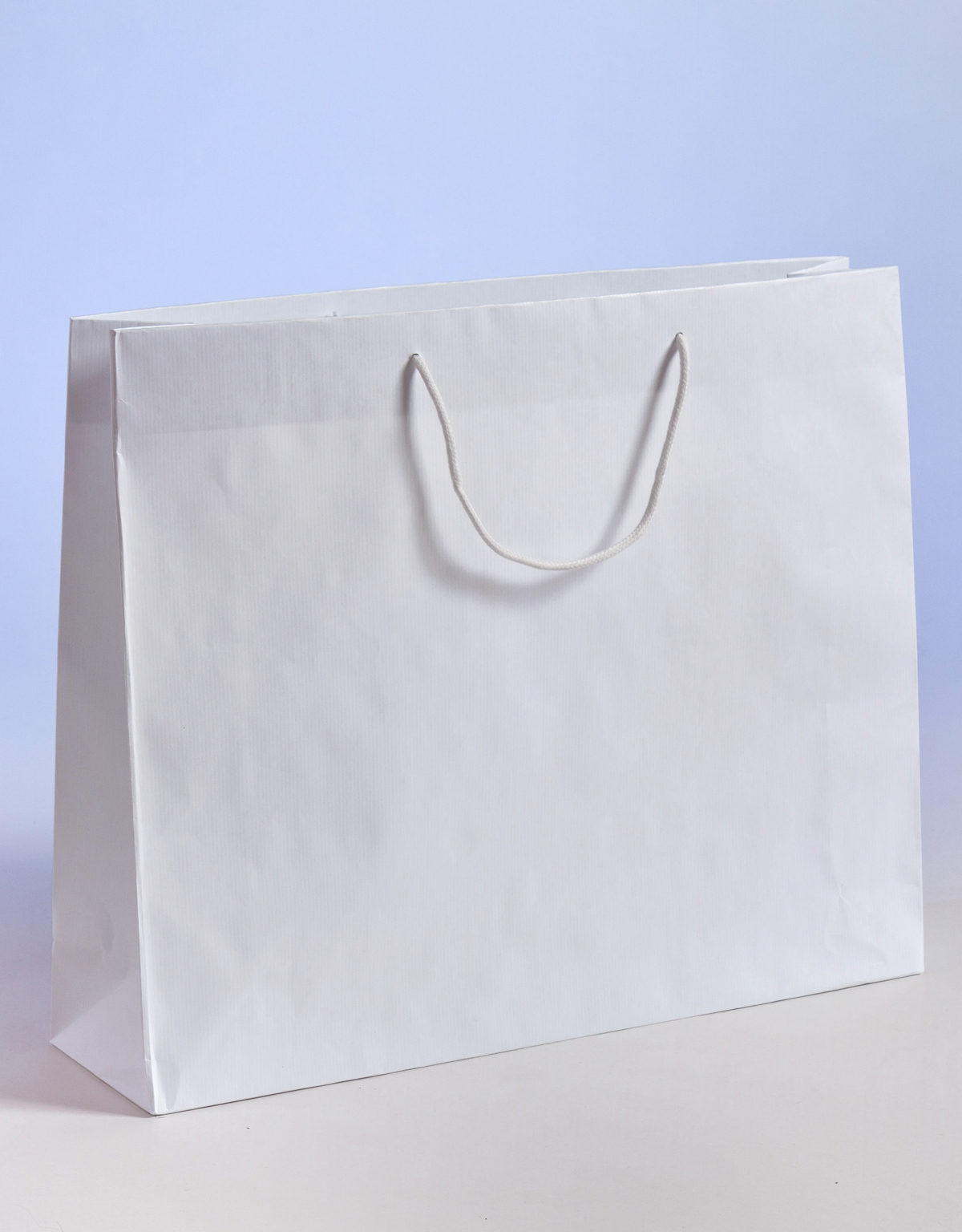 Produktbild SALE Papiertragetaschen aus Sealingpapier (gerippt) mit Kordel weiß  in der Größe 54 x 14 x 44,5 + 6 cm